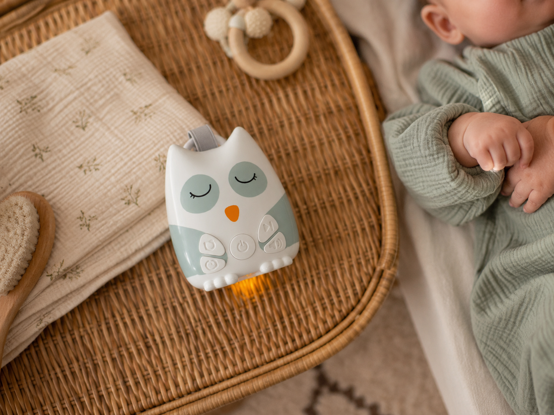 Nouna sleep soother beside a sleeping baby in a bassinet